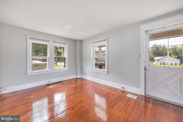 interior space featuring wood-type flooring, visible vents, and baseboards