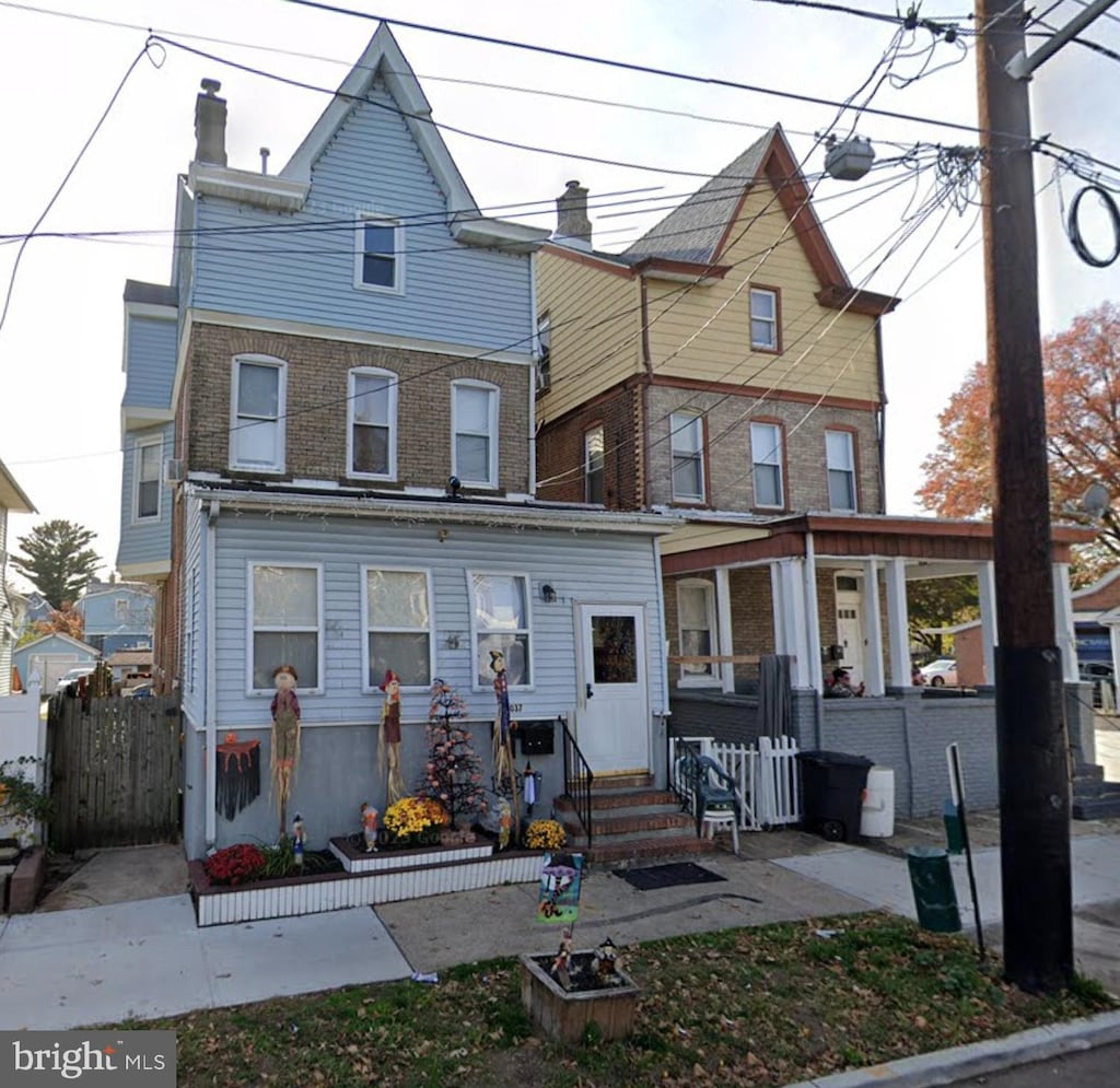 view of front of home with entry steps, fence, and brick siding