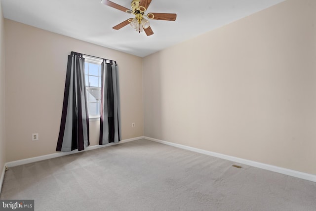 spare room featuring baseboards, light colored carpet, and ceiling fan