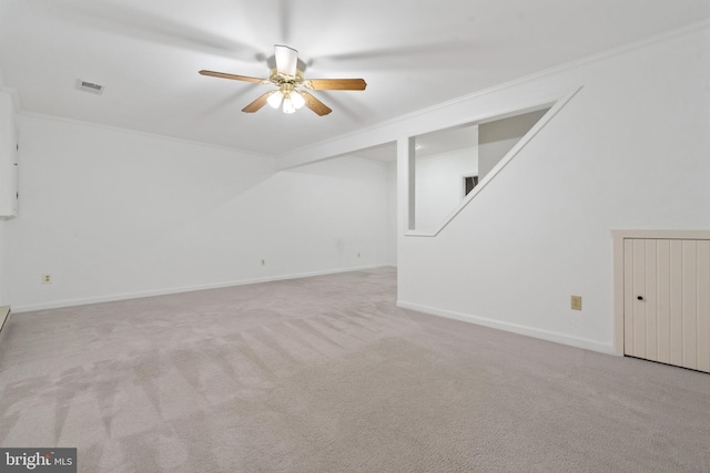 interior space featuring visible vents, a ceiling fan, ornamental molding, and carpet flooring