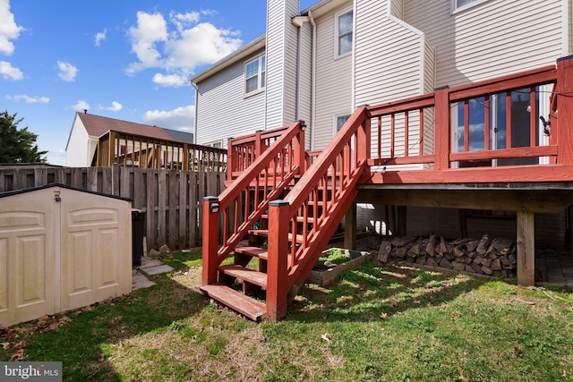 exterior space featuring fence, stairs, a lawn, a storage shed, and an outbuilding