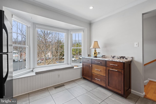 bathroom featuring wainscoting, visible vents, a healthy amount of sunlight, and ornamental molding