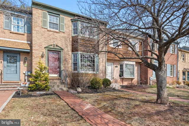 townhome / multi-family property with brick siding and a balcony