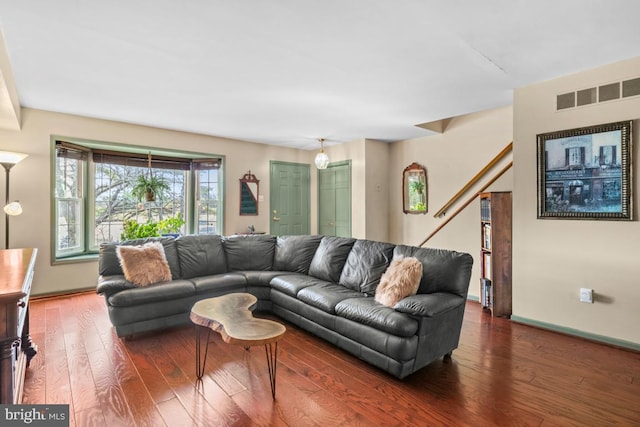 living area with hardwood / wood-style floors, baseboards, and visible vents