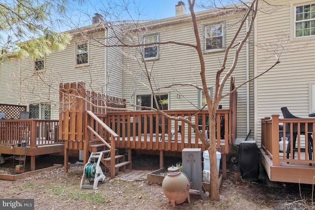 back of property featuring a wooden deck and a chimney