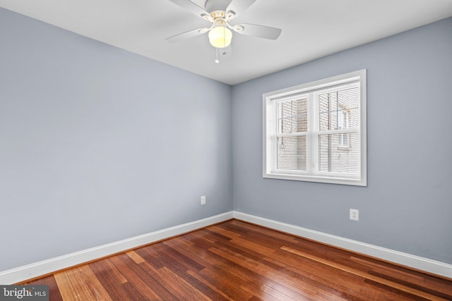 spare room with ceiling fan, dark wood finished floors, and baseboards