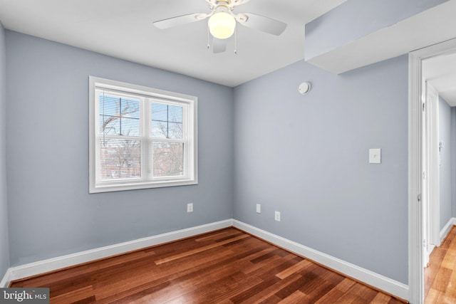 spare room with ceiling fan, baseboards, and wood finished floors