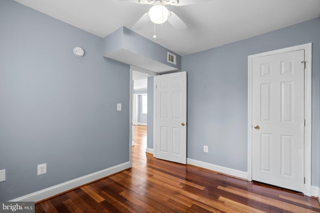 unfurnished bedroom with wood finished floors, visible vents, and baseboards