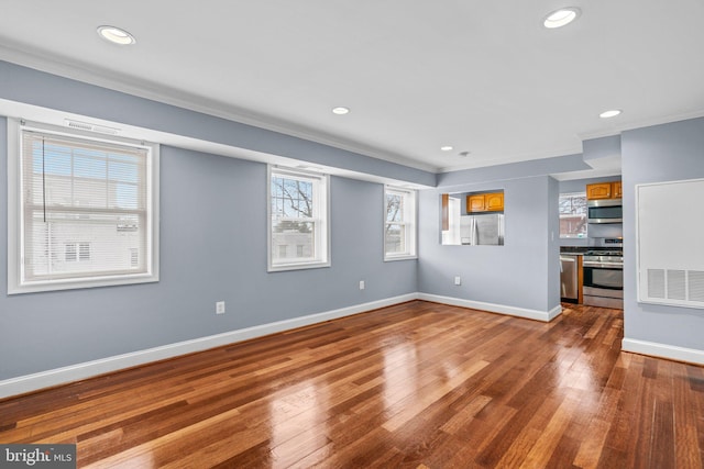 unfurnished living room featuring hardwood / wood-style flooring, baseboards, crown molding, and recessed lighting