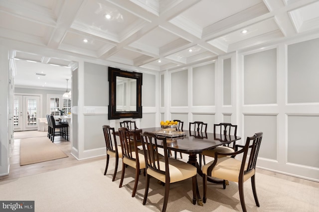 dining room with beam ceiling, a decorative wall, and coffered ceiling