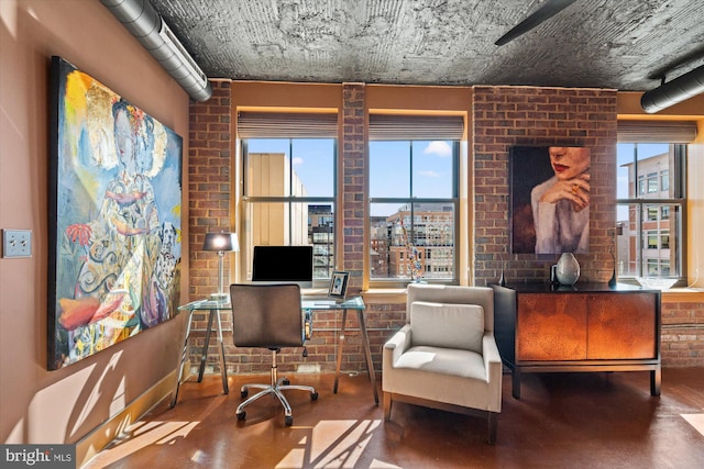 office featuring brick wall and concrete flooring