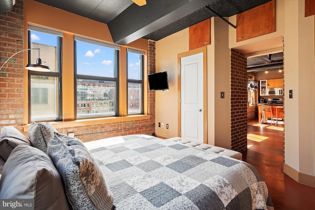 bedroom featuring beamed ceiling and brick wall