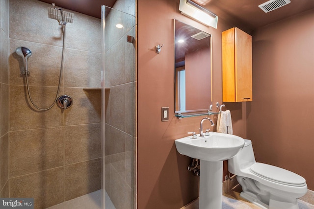 bathroom featuring visible vents, toilet, and tiled shower