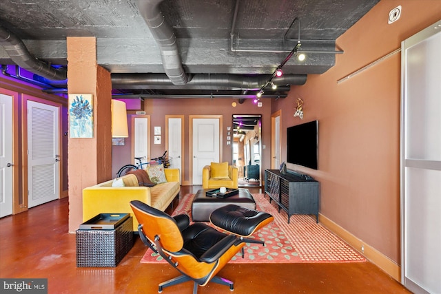 living area featuring baseboards and concrete flooring