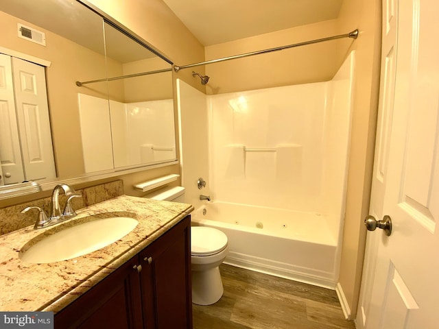 full bath with visible vents, toilet, wood finished floors, bathtub / shower combination, and vanity