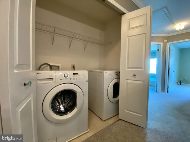 laundry area with laundry area, light colored carpet, crown molding, and separate washer and dryer