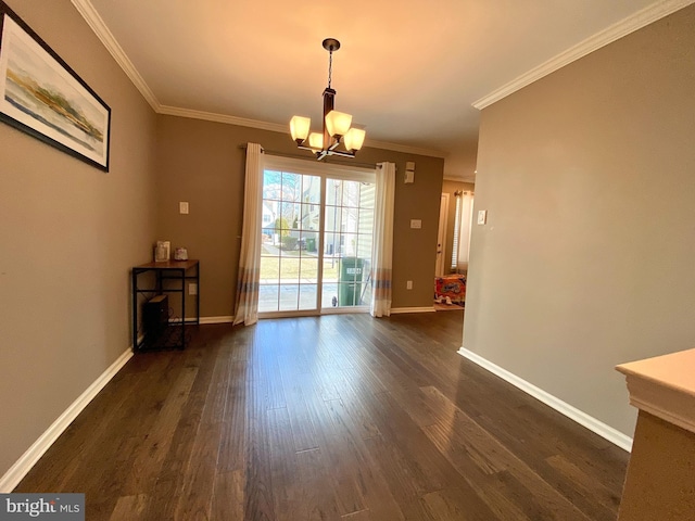 unfurnished dining area featuring ornamental molding, dark wood finished floors, baseboards, and an inviting chandelier