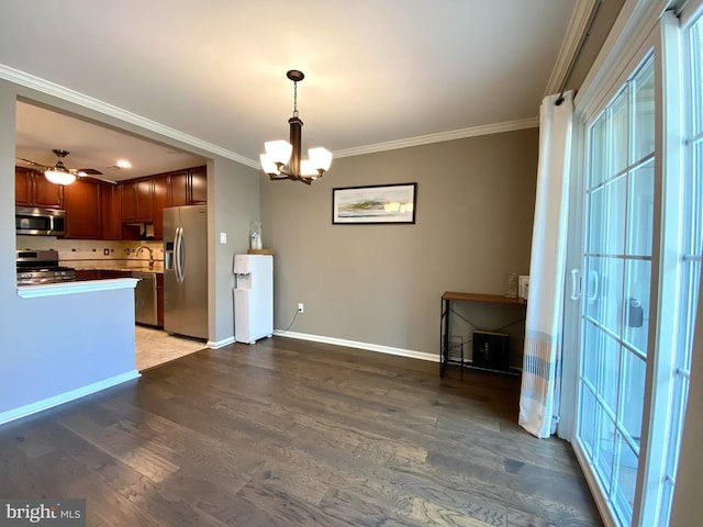 kitchen featuring ornamental molding, stainless steel appliances, wood finished floors, and a sink