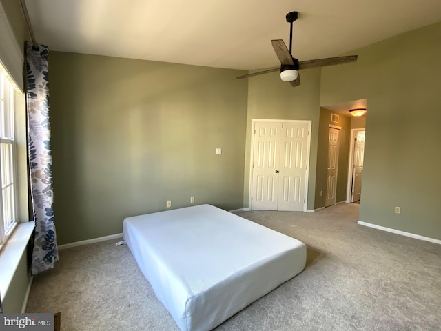 carpeted bedroom featuring lofted ceiling, ceiling fan, and baseboards