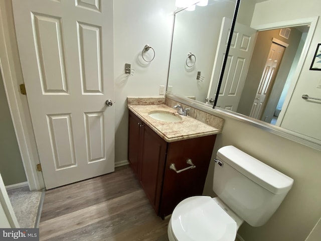 bathroom with vanity, toilet, and wood finished floors