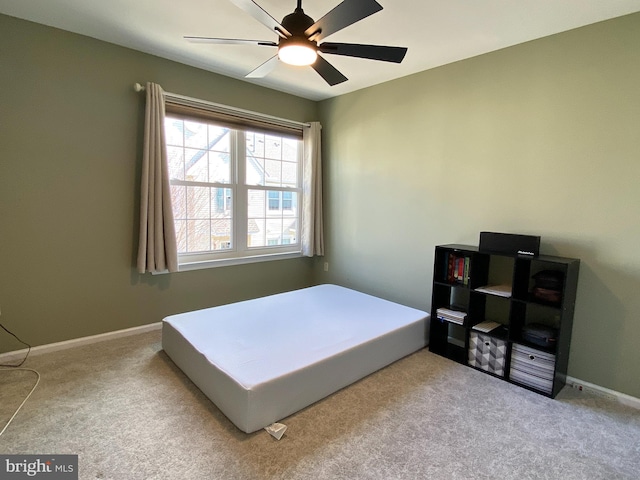 carpeted bedroom featuring baseboards and a ceiling fan