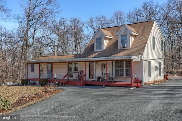 view of front facade with covered porch and roof with shingles