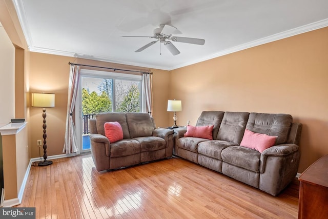 living room with crown molding, light wood-style flooring, and baseboards