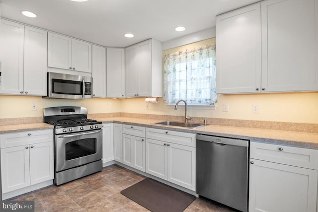 kitchen with a sink, light countertops, white cabinetry, and stainless steel appliances