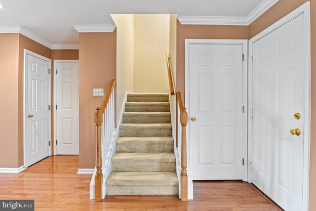 entryway featuring light wood-type flooring, stairway, baseboards, and ornamental molding