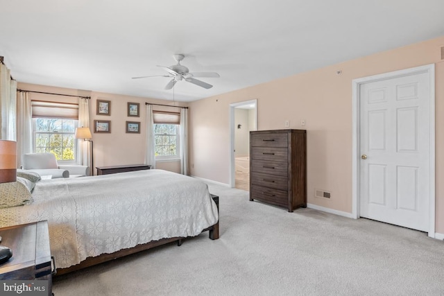 bedroom with multiple windows, light colored carpet, visible vents, and baseboards