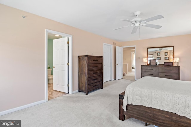 bedroom with light carpet, connected bathroom, a ceiling fan, and baseboards