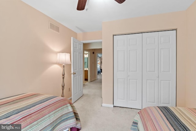 bedroom featuring a ceiling fan, visible vents, baseboards, a closet, and light colored carpet