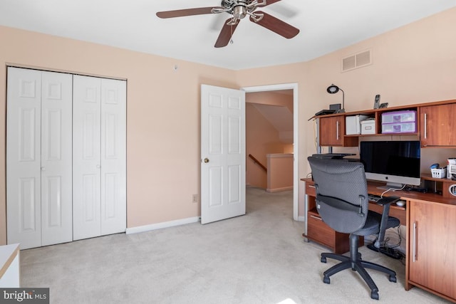 office area with visible vents, light colored carpet, a ceiling fan, and baseboards