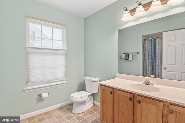 full bath featuring a shower with shower curtain, baseboards, toilet, and vanity