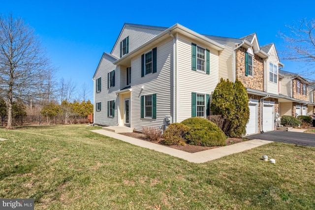 view of front of property featuring a front yard, an attached garage, and driveway