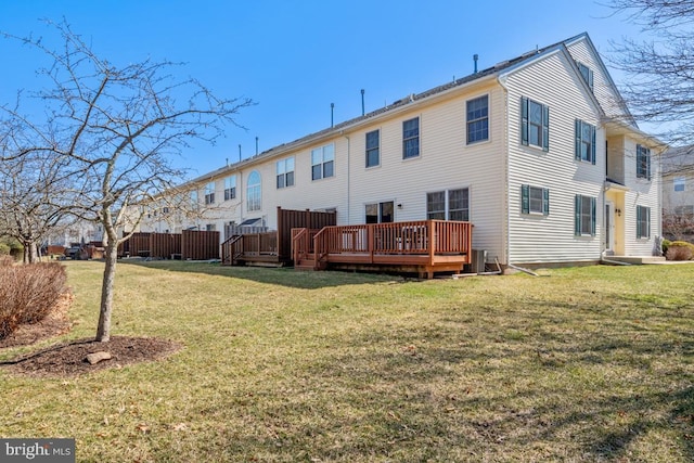 back of house with central AC unit, a lawn, and a wooden deck