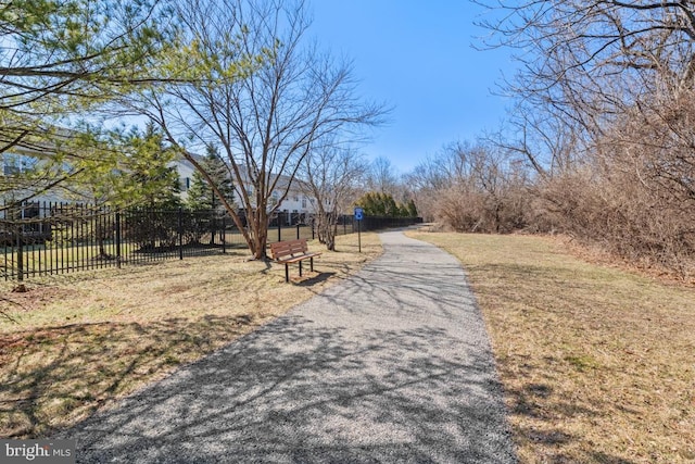 view of home's community featuring a lawn and fence