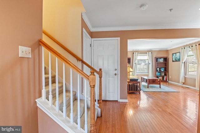 entrance foyer featuring hardwood / wood-style flooring, stairway, baseboards, and ornamental molding