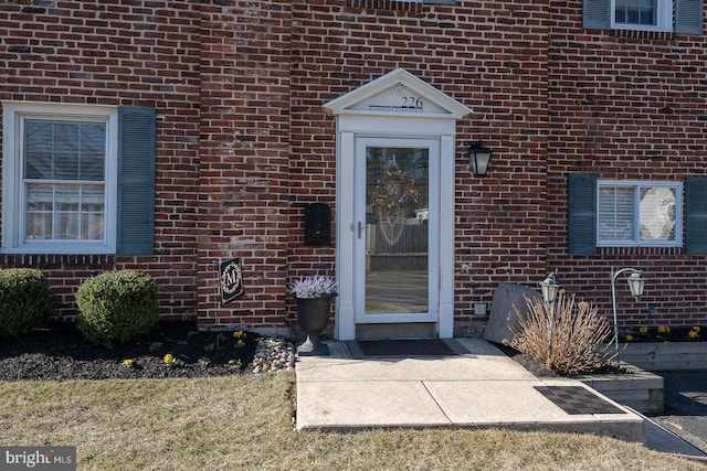 view of exterior entry featuring brick siding