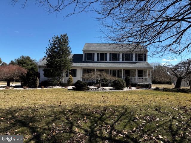 view of front of house with covered porch and a front lawn