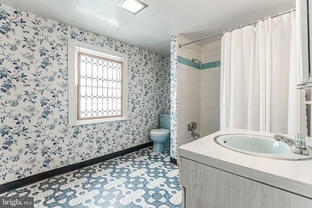 full bath featuring toilet, wallpapered walls, baseboards, and vanity