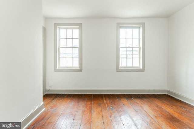 empty room featuring baseboards and hardwood / wood-style floors