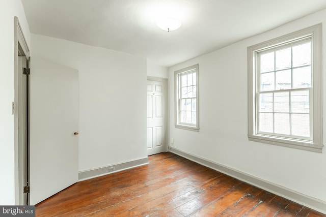 unfurnished room featuring baseboards and hardwood / wood-style floors