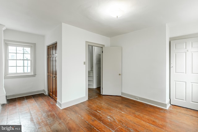 unfurnished bedroom featuring baseboards and hardwood / wood-style floors