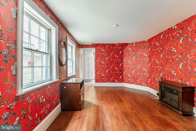 living room with a healthy amount of sunlight, wallpapered walls, and baseboards