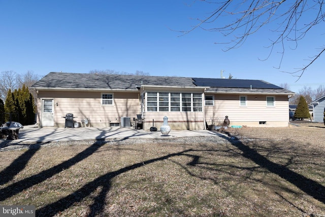 rear view of property with solar panels and a patio