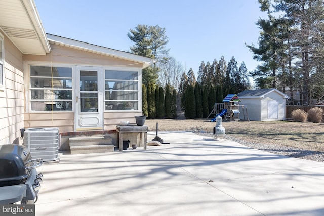 view of patio / terrace with entry steps, a storage shed, central AC, an outdoor structure, and grilling area