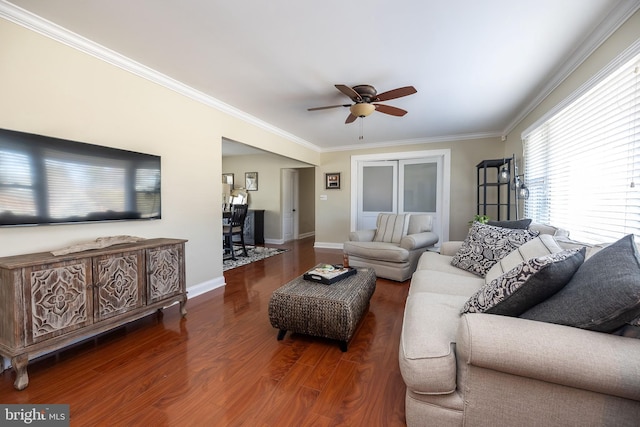 living area featuring baseboards, wood finished floors, a ceiling fan, and crown molding