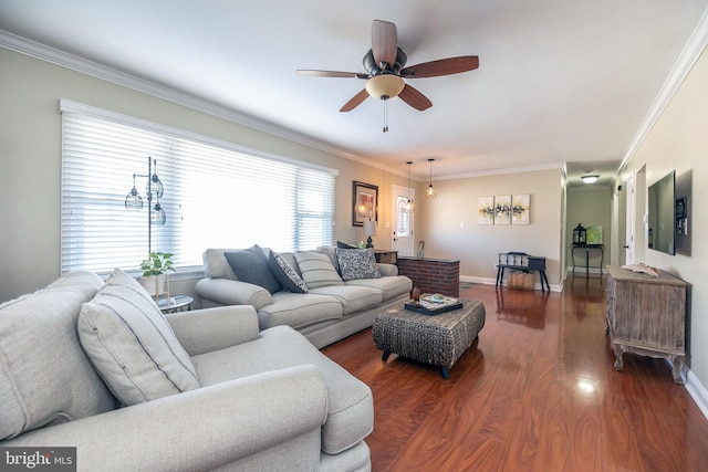 living room with ornamental molding, baseboards, and wood finished floors