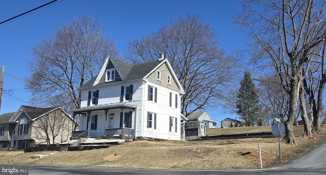 view of front of house featuring covered porch and a chimney